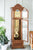 Reloj de pie de madera con puerta lateral abierta y mecanismo de péndulo visible