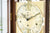Primer plano de la esfera de un reloj de pie con números romanos y adornos dorados