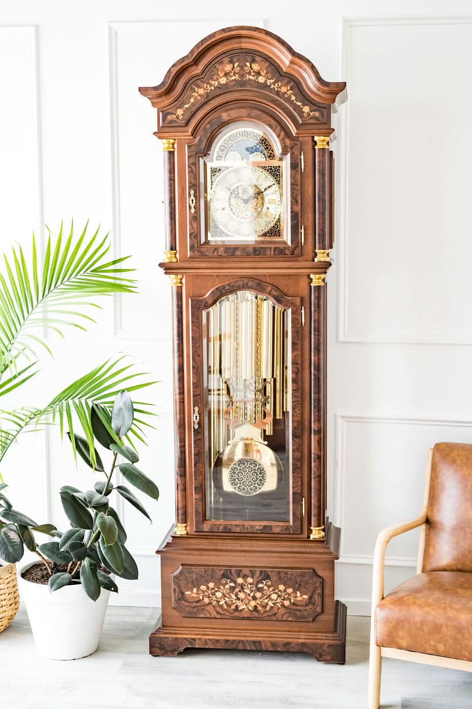 Reloj de pie de madera con caja tallada y esfera visible a través del cristal