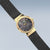 "Reloj de mujer con esfera de mármol azul, caja dorada y correa de malla negra."