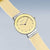 "Reloj de mujer con esfera redonda amarilla y correa beige, corona lateral"
