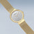 "Reloj Bering para mujer con bisel dorado, esfera plateada y marcadores dorados"