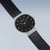 Reloj Bering para mujer, vista en ángulo, esfera negra con índices y bisel plateado