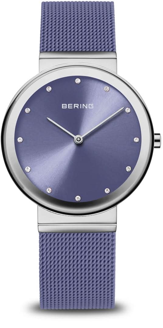 Reloj de mujer con correa milanesa morada, caja redonda plateada y esfera azul.