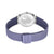 Reloj de mujer con correa Milanesa morada y cierre; fondo de acero inoxidable visible.