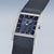 "Reloj de mujer con esfera rectangular azul, bisel transparente y correa de malla metálica azul oscuro"