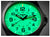 Pulsera de hombre primer plano: esfera verde luminosa con manecillas y números.