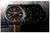 Reloj de hombre con esfera negra e índices luminosos en verde/naranja; correa de textil negro