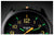 Vista frontal de reloj para hombre: esfera negra, índices luminosos verdes y amarillos, acento naranja en el logo