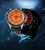 Dos relojes de pulsera para hombre con esfera naranja, caja negra y correa de caucho.