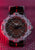 Pulsera de hombre con esfera oscura, marcadores luminosos y correa textil negra con raya roja