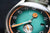 Reloj de hombre: esfera turquesa con logo UMF, marcadores naranjas, bisel plateado