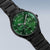 Reloj de hombre con correa de metal negra y esfera verde con subesferas y manecillas de cronógrafo