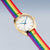 "Reloj de mujer con caja dorada, esfera blanca y correa textil multicolor"