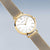 "Reloj de mujer con esfera redonda blanca y pulsera de malla dorada"