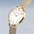 "Reloj de mujer con esfera blanca, manecillas redondas y correa de malla dorada"