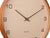Wanduhr-Detail: sandbrauner Rahmen, beiges Zifferblatt mit Zeigern und schwarzen Ziffern