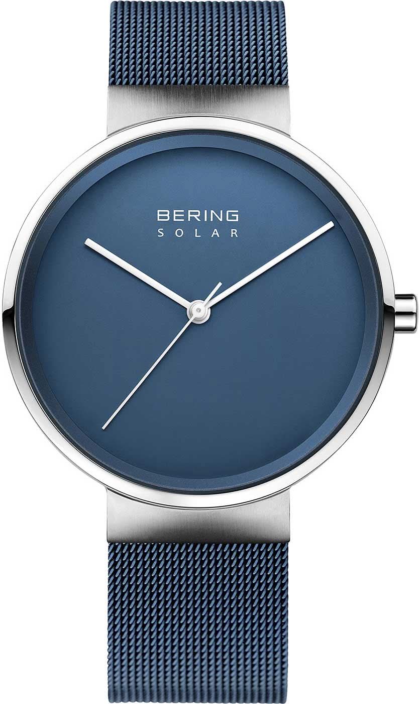 "Reloj analógico Bering Solar con esfera azul y caja plateada, correa de malla milanesa azul."