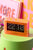 Neonorange Tischuhr mit transparentem Acrylgehäuse und Klappzahlen, zeigt 22 und 10.