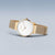 Reloj dorado para mujer con esfera blanca y correa milanesa, visto de lado