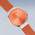 Reloj analógico de lado: esfera naranja y correa milanesa naranja