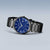 Reloj de hombre con esfera azul y correa de eslabones negra, vista de tres cuartos