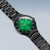 Reloj de hombre de lado con esfera verde, índices blancos y correa de metal negra