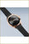 "Reloj de mujer, vista inclinada: esfera negra, caja de oro rosa, correa de metal negra"