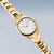 Reloj de mujer en tono dorado, diagonal: esfera blanca con índices, brazalete de eslabones