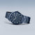 "Reloj Bering para hombre, vista lateral: esfera azul oscuro con índices y pulsera de eslabones metálicos"