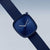 Reloj de mujer con esfera azul sobre correa de tela azul oscuro, vista lateral