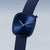 Reloj de mujer con esfera azul sobre correa de tela azul oscuro, vista en ángulo