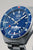 Pulsera de hombre con brazalete de metal plateado y esfera azul, índices y manecillas luminosos