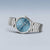 "Reloj de mujer con esfera azul y brazalete de acero inoxidable, en diagonal desde el frente"