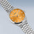 Reloj de hombre con esfera naranja y pulsera de acero inoxidable plateado, en ángulo