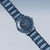 "Reloj de mujer con pulsera de cerámica azul en ángulo, caja redonda"