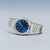 Pulsera de hombre con esfera azul, brazalete de metal plateado y vista de la corona.