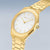 Reloj de hombre dorado con esfera blanca, corona lateral y correa milanesa