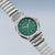 "Reloj de hombre con esfera verde y caja plateada de acero inoxidable, detalle de la correa del reloj"
