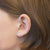Pendientes de corazón en la oreja con pequeña piedra rosa