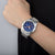 Reloj Festina para hombre en la muñeca, correa de acero plateado y esfera azul con cronógrafo