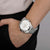 Reloj de hombre en la muñeca: correa de acero inoxidable plateada y esfera blanca de cronógrafo