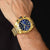 Reloj de hombre cronógrafo en la muñeca con esfera azul y caja dorada