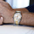 Pulsera de hombre en la muñeca con correa de acero inoxidable bicolor y esfera blanca