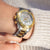 "Reloj de mujer en la muñeca con esfera blanca y detalles dorados, pulsera de acero inoxidable"