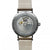 Vista trasera de un reloj de pulsera para hombre: movimiento visible, correa de cuero beige, acero inoxidable