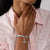 Colgante de Snoopy en pulsera: detalle de charm plateado con rodillo azul en la muñeca