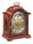 Reloj de mesa de caoba con esfera redonda y marco ornamental, frontal cerrado
