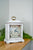 Reloj de mesa blanco con esfera floral y correa de transporte dorada