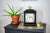 "Reloj de mesa negro con esfera floral sobre cómoda, ojal superior dorado"